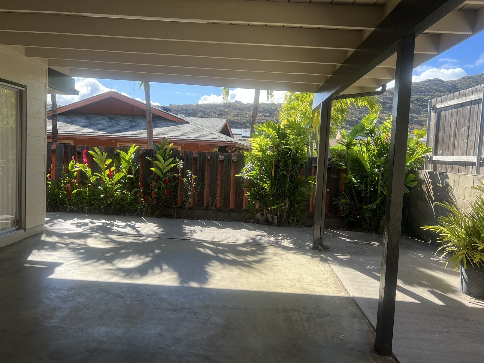 A patio with a roof and plants.